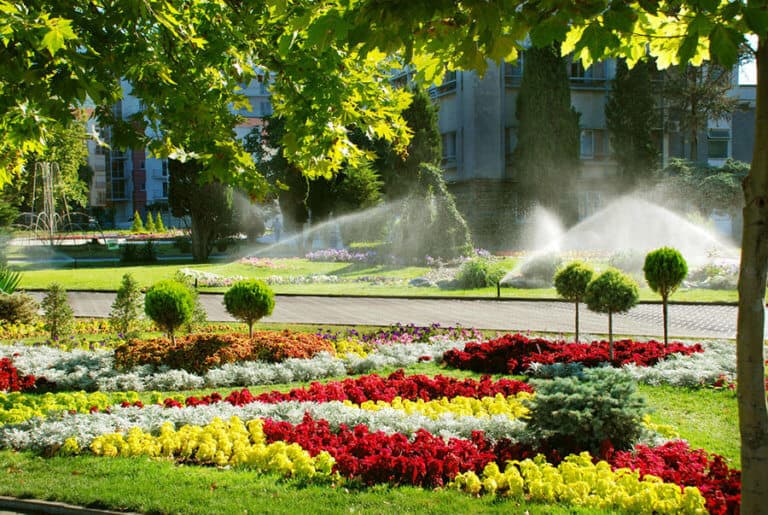 City square. Sprinkler system is watering the lawn.